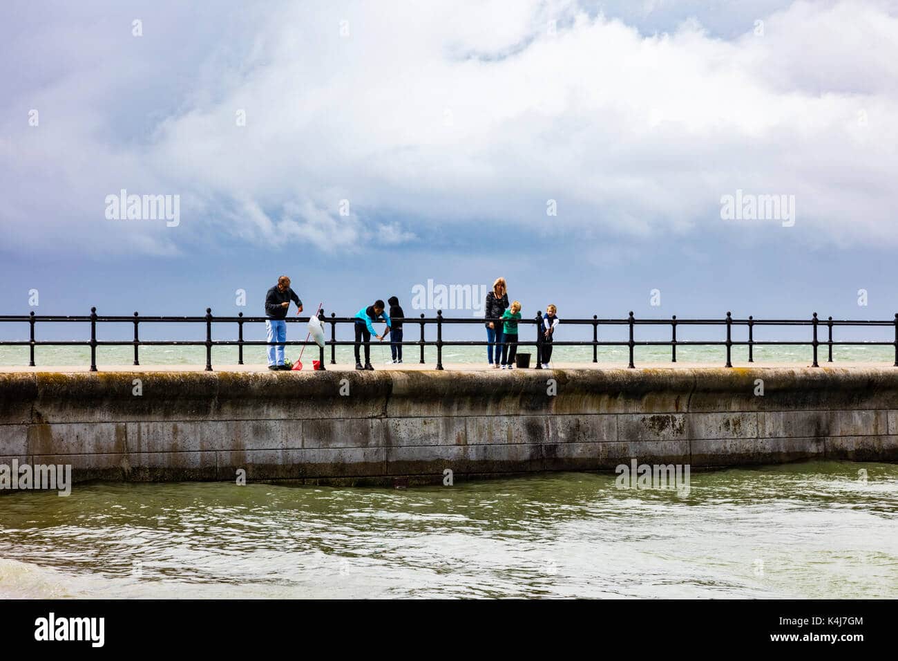 a-family-fish-for-crabs-from-the-pier-at-hampton-herne-bay-kent-under-K4J7GM